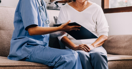 Doctor showing medical card to patient at table in clinic, closeup