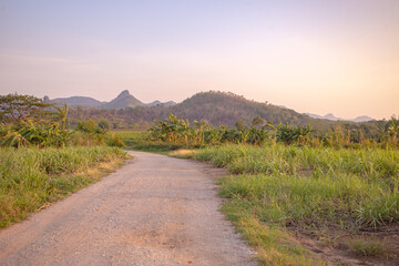 Country road down from the hill, mountain far away ahead, Thailand.