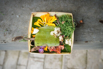 Traditional balinese offerings to gods in Bali with flowers and aromatic sticks. Balinese Hindu...