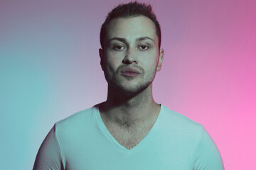 Obraz premium King of the hill concept. Close up portrait of stylish young man in neon lights with domineering. Retro, vintage style. Studio shot