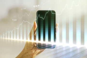 Abstract creative financial graph and hand with phone on background, forex and investment concept....