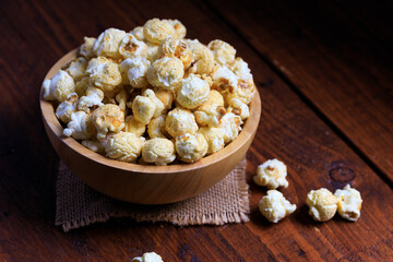 Close up Popcorn in the wooden bowl on wooden background
