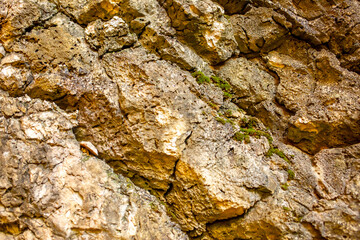 Natural rock texture background. Rocky bas-relief wall.