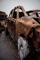 a burnt-out car broken by shrapnel