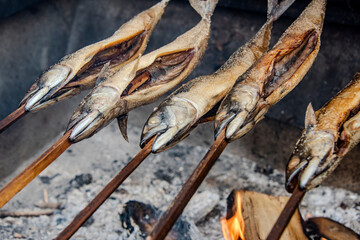 Barbecue stockfish grilled trout fish on stocks with fire smoke