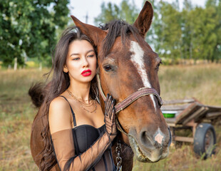 Fototapeta premium Beautiful young caucasian woman standing near the horse.