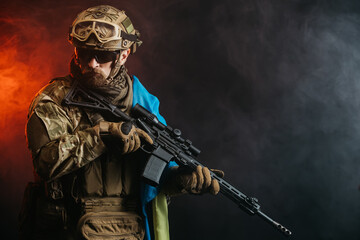 Ukrainian special forces soldier or private military contractor with rifle and Ukrainian flag. Image on a black and red background. The concept of war, army, weapons and computer games.