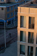 Brick apartment building during golden hour and a cyclist on the street
