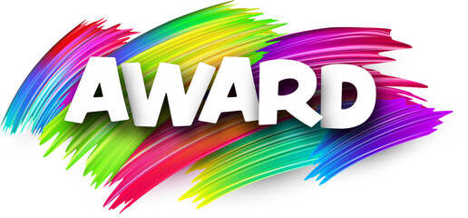 Award paper word sign with colorful spectrum paint brush strokes over white.