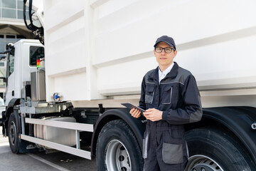 Manager with a digital tablet next to garbage truck