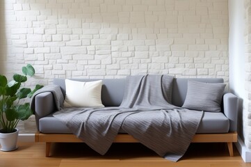 Fabric sofa with grey pillow and blanket against stucco wall. AI Generated