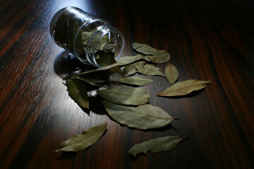 Bay leaves isolated. Bay leaves in a jar on wooden background. Brazilian seasonings.