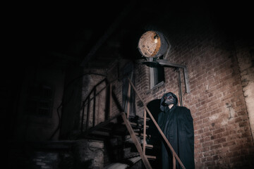A man in a Venetian plague doctor mask with glowing red eyes against the background of an ancient...
