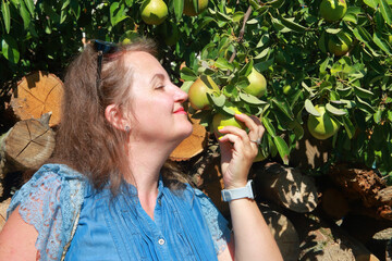 A woman tastes the smell of ripe pears.