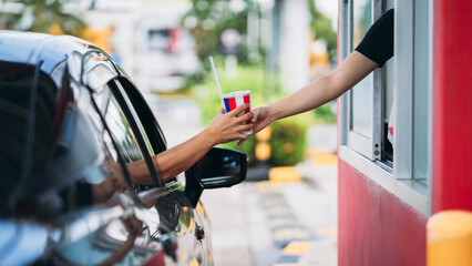 Young Man receiving coffee at drive thru counter., Drive thru and take away for protect covid19..