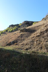 A grassy hill with a hill in the background