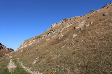 Fototapeta na wymiar A rocky hill with a grassy hill