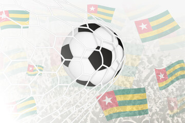 National Football team of Togo scored goal. Ball in goal net, while football supporters are waving the Togo flag in the background.