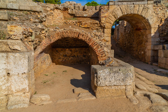 Restored arch entrances to the arena of the Roman Amphitheater of Mérida illuminated by the light of dawn creating shadows in its tunnels towards the stands. World Heritage City.