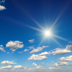Bright sun on beautiful blue sky with white clouds.