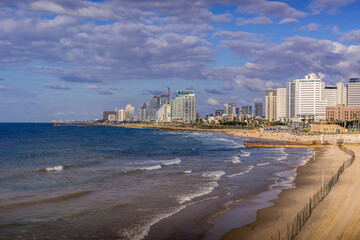 The view of Tel Aviv Bugrashov sandy beach with the Mediterranean sea coastline, and resort hotels along the watefront.