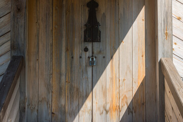 a massive wooden door to a log house. buildings in the village