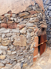Old stone wood oven with iron door. Close up of traditional stone construction. Architecture and...
