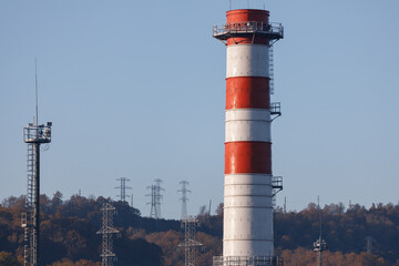 Red and white power plant pipe on the background of power transmission lines