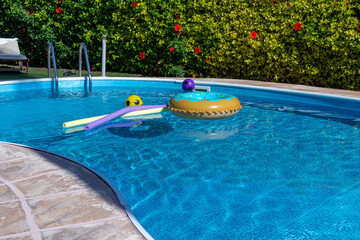 Swimming pool with children's equipment. Swimsuit, ball and swimming equipment in the pool