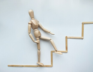 A wooden puppet climbs up the stairs