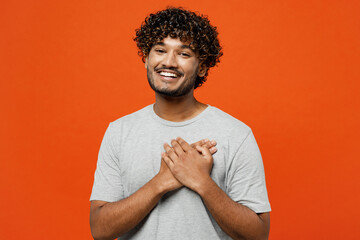 Young cheerful smiling fun happy grateful Indian man he wears t-shirt casual clothes put folded...