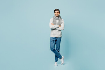 Fototapeta na wymiar Full body smiling young ill sick man wear gray sweater scarf hold hands crossed folded isolated on plain blue background studio. Healthy lifestyle disease virus treatment cold season recovery concept.