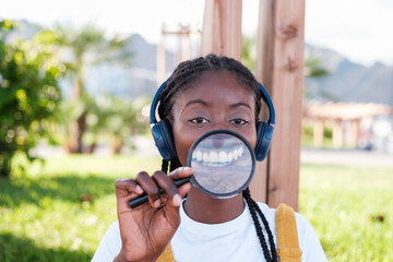 Young woman with a magnifying glass widening her smile. Concept: smiles, lifestyle, fun