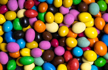 Fototapeta na wymiar A Colorful Delight of Candy Eggs Nestled Together. A close up of a pile of candy eggs