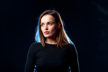 A woman in a black shirt is posing for a picture. A Captivating Woman in a Sleek Black Shirt Poses...