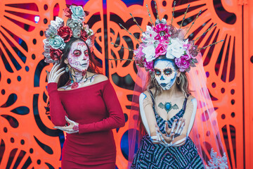 Mexican woman dressed and characterized as a catrina for the Day of the Dead festivity, behind her...