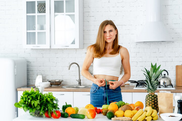 A woman standing in a kitchen with fruits and vegetables. A Woman Preparing a Healthy Meal in a Bright, Vibrant Kitchen