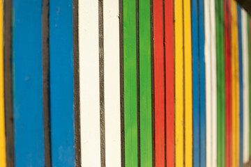 Colored fence. Beautiful fence. Different color on boards. Painted material.