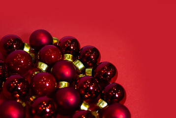 Christmas decorations, Top view of Pile of Red Glass balls on red background, useful as a greeting gift card template. Red Christmas baubles decoration on red background with copy space.
