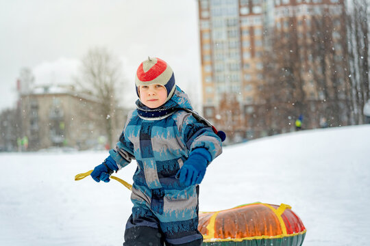 cute caucasian with snow tubing in park . Winter activities concept. Happy childhood. Image with selective focus.