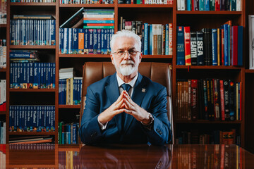 Experienced University Rector Posing in Library with Academic Books