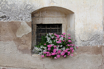 finestrella fiorita in una casa antica di Vigo di Fassa