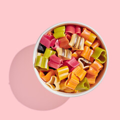 Colorful heart shaped pasta closeup on pink background