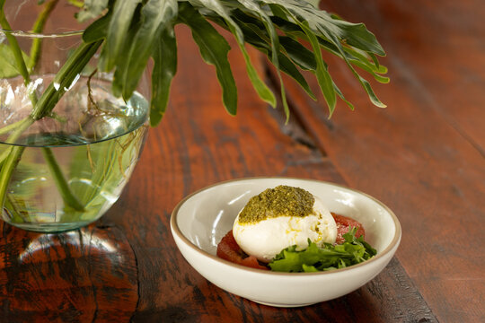 Burrata con pesto, jitomate y r&uacute;cula 
