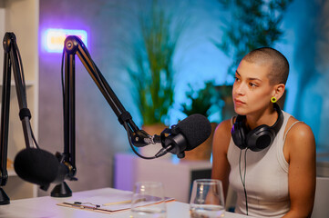 Portrait of a podcast host sitting in a broadcast home studio during an interview.