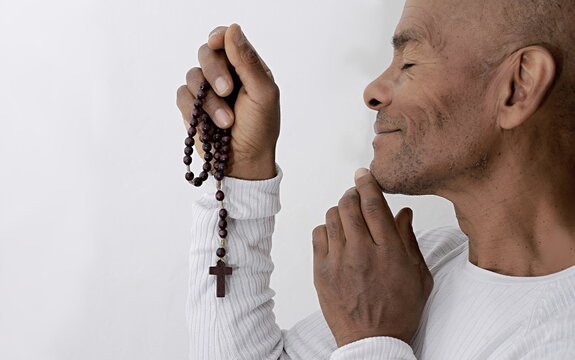 man praying to God with the bible on black background with people stock image stock photo