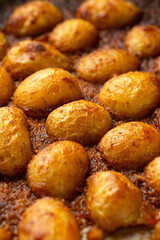 Parmesan crusted baby new potatoes on a baking tray
