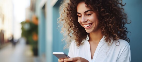 Close up of a woman smiling while holding a smartphone and talking in a stock photo