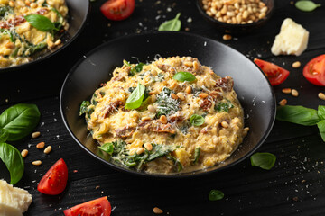 Creamy spaghetti squash pasta with parmesan cheese and sun dried tomato sauce served with pine nuts and basil.
