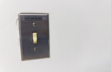 light switch in a dimly lit room, symbolizing the concept of electricity conservation and energy-saving practices in everyday life